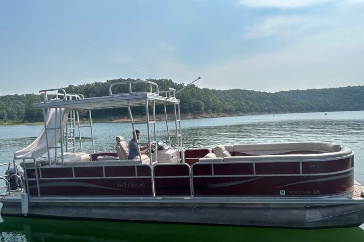 a man driving a 26' pontoon on a lake