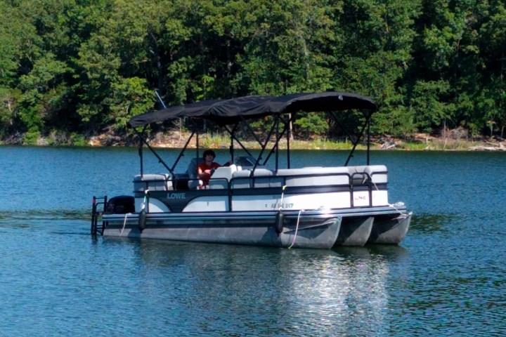 a man driving a 21' pontoon on a lake